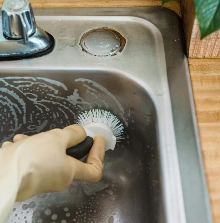 Scrubbing a sink as part of deep cleaning services in Dallas